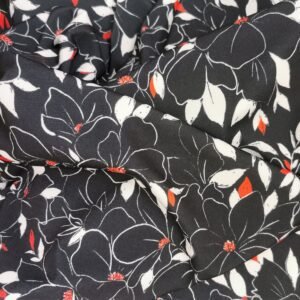 Punto de viscosa negra con flores tropicales blancas